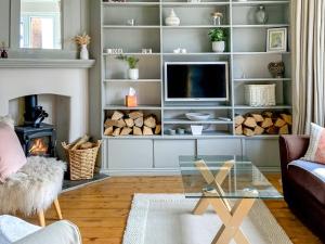 a living room with a tv and a fireplace at The Warblers in Minehead