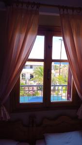 a bedroom with a window with a view of a pool at Anessis Studios in Anaxos