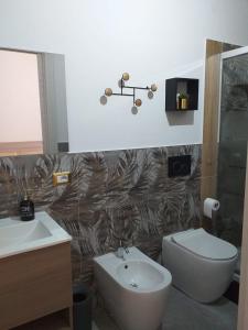 a bathroom with a sink and a toilet at Affittacamere da Arianna in Porto Torres
