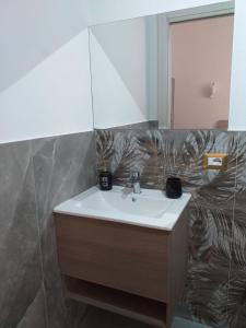 een badkamer met een wastafel en een spiegel bij Affittacamere da Arianna in Porto Torres