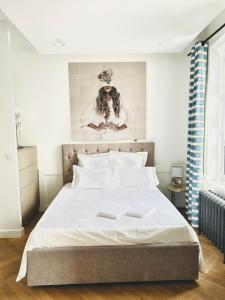 a bedroom with a large white bed with two folders at Suite Clémenceau in La Baule