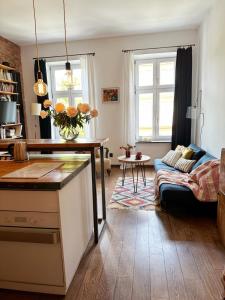 een keuken en een woonkamer met een tafel en een bank bij Lofts Cracow Apartments - City Center in Krakau