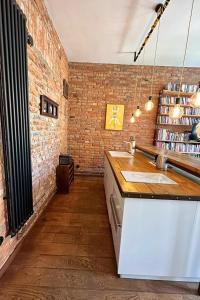 a kitchen with a sink and a brick wall at Lofts Cracow Apartments - City Center in Krakow