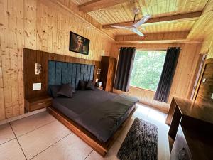 - une chambre avec un lit et un ventilateur de plafond dans l'établissement Odin Hostel Kasol, à Kasol