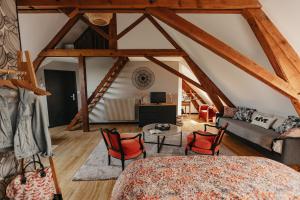 een woonkamer met houten balken en een bank en stoelen bij LE CLOS POULAIN Petits gîtes de charme et chambres d'hôtes Familiales au calme proche Bayeux et des plages in Nonant