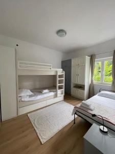 a white bedroom with a bed and a desk at Holiday house Fila in Turanj