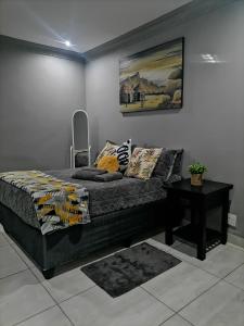 ポロクワネにあるLady D Exclusive Abodeのベッドルーム1室(ベッド1台、テーブル、絵画付)