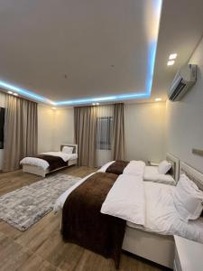 a large bedroom with two beds and a blue light at شالية مارينا مرباط in Mirbāţ +7 photos