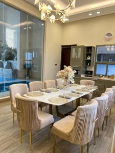 a dining room with a large table and chairs at شالية مارينا مرباط in Mirbāţ