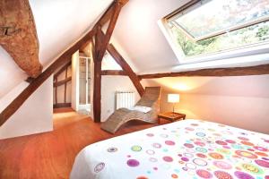 1 dormitorio en el ático con cama y ventana en Domaine de la Folicoeur, en Sainte-Colombe-près-Vernon