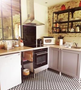 a kitchen with a black and white tiled floor at Domaine de la Folicoeur in Sainte-Colombe-près-Vernon