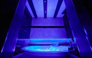 a room with a tub with purple lights in it at Mamaco I Teatro Rooms in Foggia