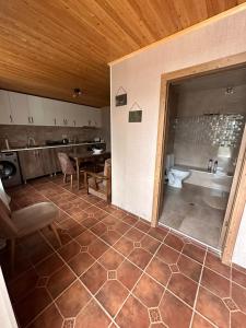 a room with a kitchen with a table and a toilet at Apartments Gio-Nika in Stepantsminda