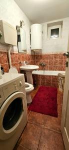 een badkamer met een toilet, een wastafel en een wasmachine bij Anastasija in Novi Sad