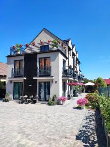 un edificio blanco con balcones, mesas y sillas en 4 Foxes, en Ustka