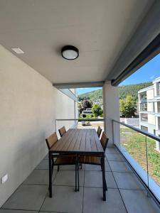 d'un balcon avec une table et des chaises en bois. dans l'établissement The R Apartment Passwang, KLIMA, NEU, Balkon, Parking, à Balsthal