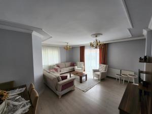 sala de estar con sofá, sillas y mesa en Deniz manzaralı klimalı daire, en Bostancı