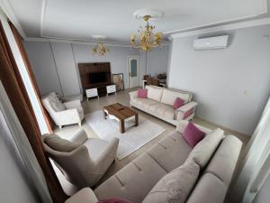 einen Blick über ein Wohnzimmer mit Sofa und Stühlen in der Unterkunft Deniz manzaralı klimalı daire in Bostancı