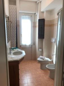 a bathroom with a sink and a toilet and a window at Annarosa in Sarzana