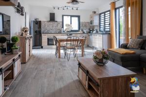 eine große Küche und ein Wohnzimmer mit einem Tisch und Stühlen in der Unterkunft L'intemporelle - Piscine et Spa in Le Tampon