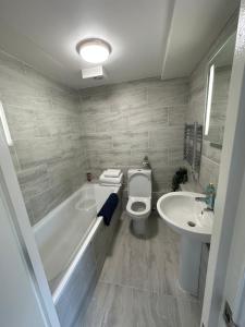 a bathroom with a tub and a toilet and a sink at Central studioflat Chelsea in London