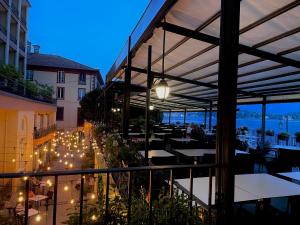 d'une terrasse avec des tables et des lumières sur un balcon. dans l'établissement Hotel Bazzoni, à Tremezzo