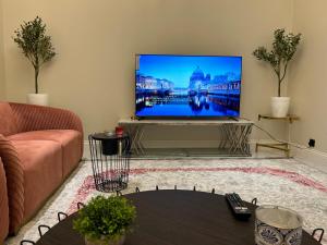 a living room with a large flat screen tv at شقة غرفة وصالة وجلسة خارجية بالعارض ٨ in Riyadh