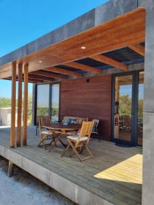 una terraza de madera con mesa y sillas. en Eco Lodge Villa das Alfarrobas com Piscina, en Algoz