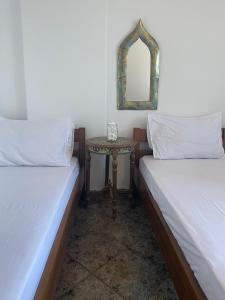 a room with two beds and a table with a mirror at Mini Beach House in Logaras +12 photos