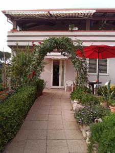 an archway with an umbrella in front of a house at B&B Kazakova in Domusnovas