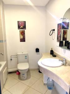a bathroom with a white toilet and a sink at Bahia golf beach in Bouznika