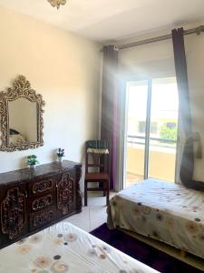 a bedroom with two beds and a mirror at Bahia golf beach in Bouznika