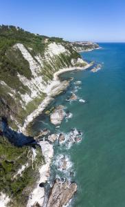una vista aerea sull'oceano e su una costa rocciosa di Fiori del Conero ad Ancona