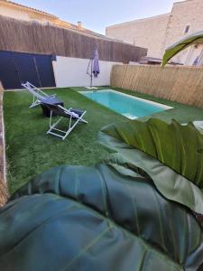 a small swimming pool with a chair and a table and a plant at Appartement cosy & piscine privée - Le Strelitzia in Vergèze
