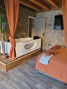 - une chambre avec un lit, un lavabo et une baignoire dans l'établissement Appartement cosy & piscine privée - Le Strelitzia, à Vergèze