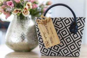 a bag with a tag on it next to a vase of flowers at Lemon Tree Villa in Paralimni