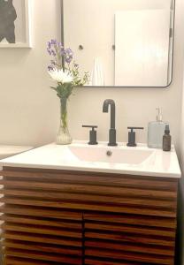 łazienka z umywalką i wazonem kwiatowym w obiekcie Chalet Retreat w/ Hot Tub, Short Walk to Lake & Pool w mieście Jim Thorpe