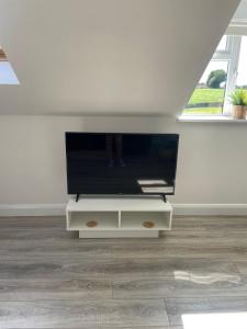 een flatscreen-tv op een stand in een woonkamer bij Grianan view loft apartment in Tieveborne