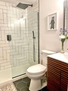 a bathroom with a toilet and a glass shower at Chalet Retreat w/ Hot Tub, Short Walk to Lake & Pool in Jim Thorpe
