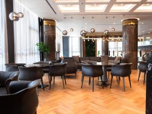 a restaurant with tables and chairs in a room at Marinaj Hotel in Tirana