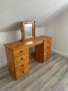 uma cómoda de madeira com um espelho em cima em Grianan view loft apartment em Tieveborne