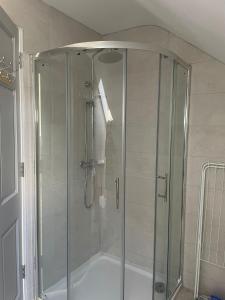 a shower with a glass enclosure in a bathroom at Grianan view loft apartment in Tieveborne