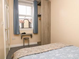 1 dormitorio con cama, escritorio y ventana en Seashells en Hornsea