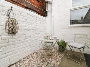 une table et deux chaises devant un mur de briques blanches dans l'établissement Seashells, à Hornsea