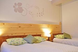 two beds in a room with white sheets at Willa Parzenica in Bukowina Tatrzańska