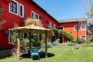 un edificio rojo con cenador en el patio en Hosteria Casagrande en Tandil