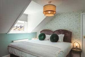 1 dormitorio con 1 cama con 2 almohadas verdes en Central Breaks - split level, spacious getaway, en Eastbourne