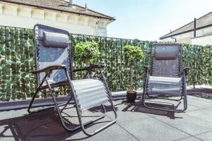 two chairs sitting on a patio in front of a fence at Central Breaks - split level, spacious getaway in Eastbourne