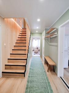 una escalera en una casa con una alfombra verde en Ruma ankanpoikanen en Pori