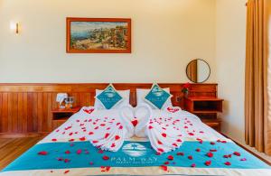 a bed with a wedding bow on it at Palm Bay Resort Phu Quoc in Phú Quốc